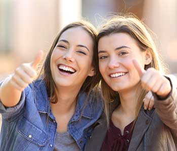 Happy young girls smilling with showing their thumb